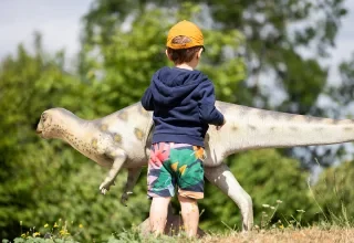 photo d'enfant devant un dinosaure à Paléopolis